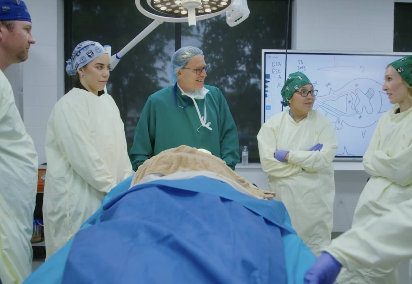 Dr. Christian and students smiling in operating room