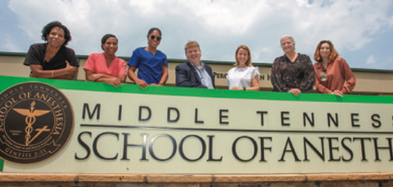 Students standing in front of the MTSA school sign