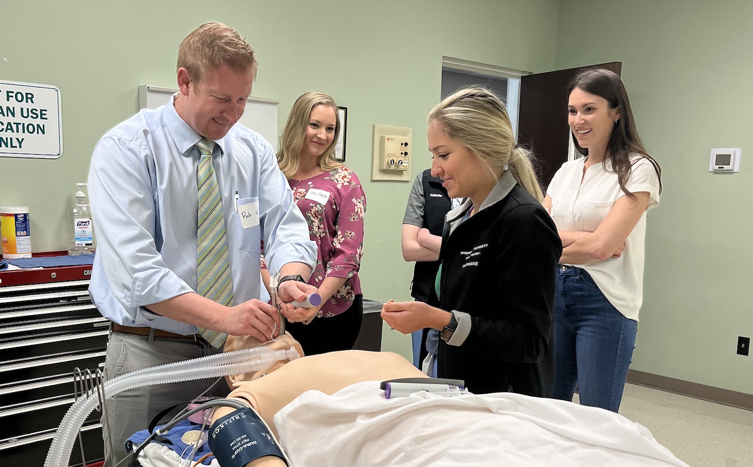 students in the simulation lab inserting an airway on a dummy patient